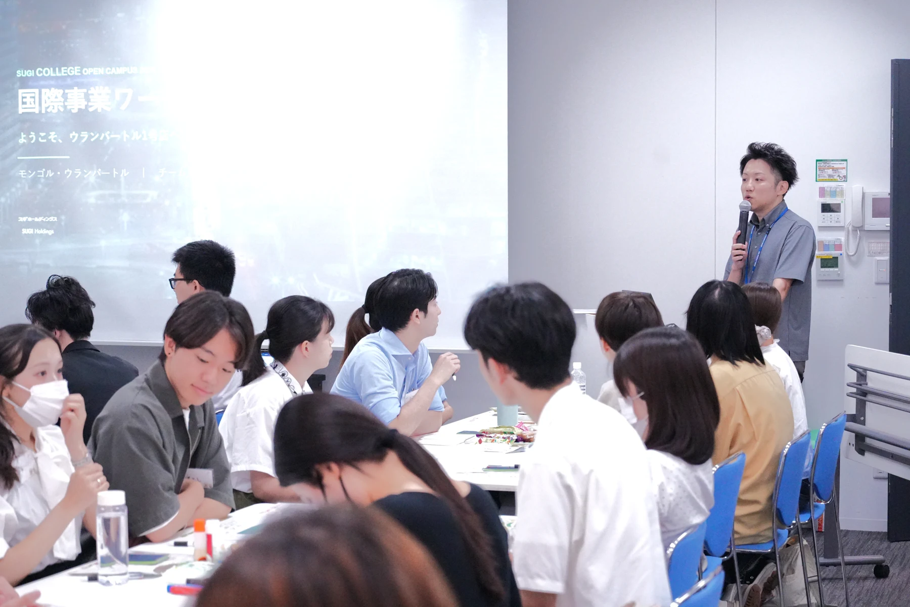 SUGI COLLEGEの教室で、前に立って話す講師と参加者
