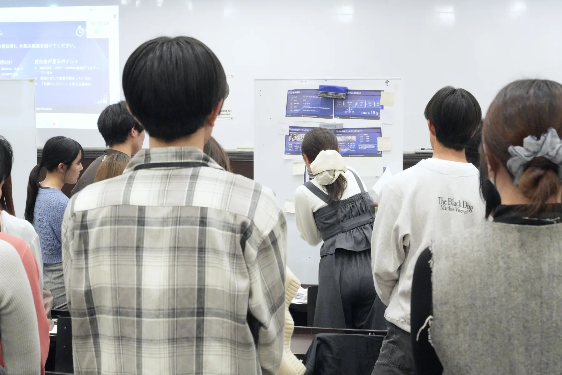 POP UP CAMPUSで、ホワイトボードの資料を使った発表を聞く参加者